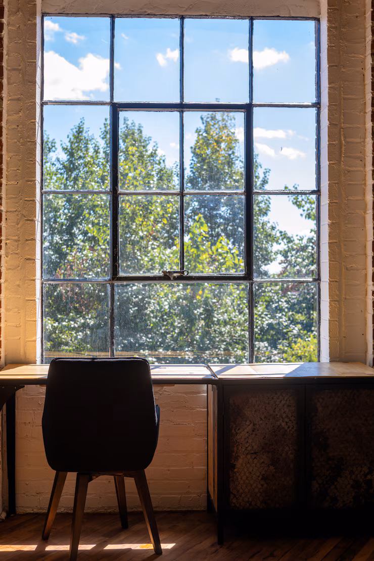 vertical-shot-chair-desk-near-large-window-with-amazing-view-greenery-outside_181624-2785